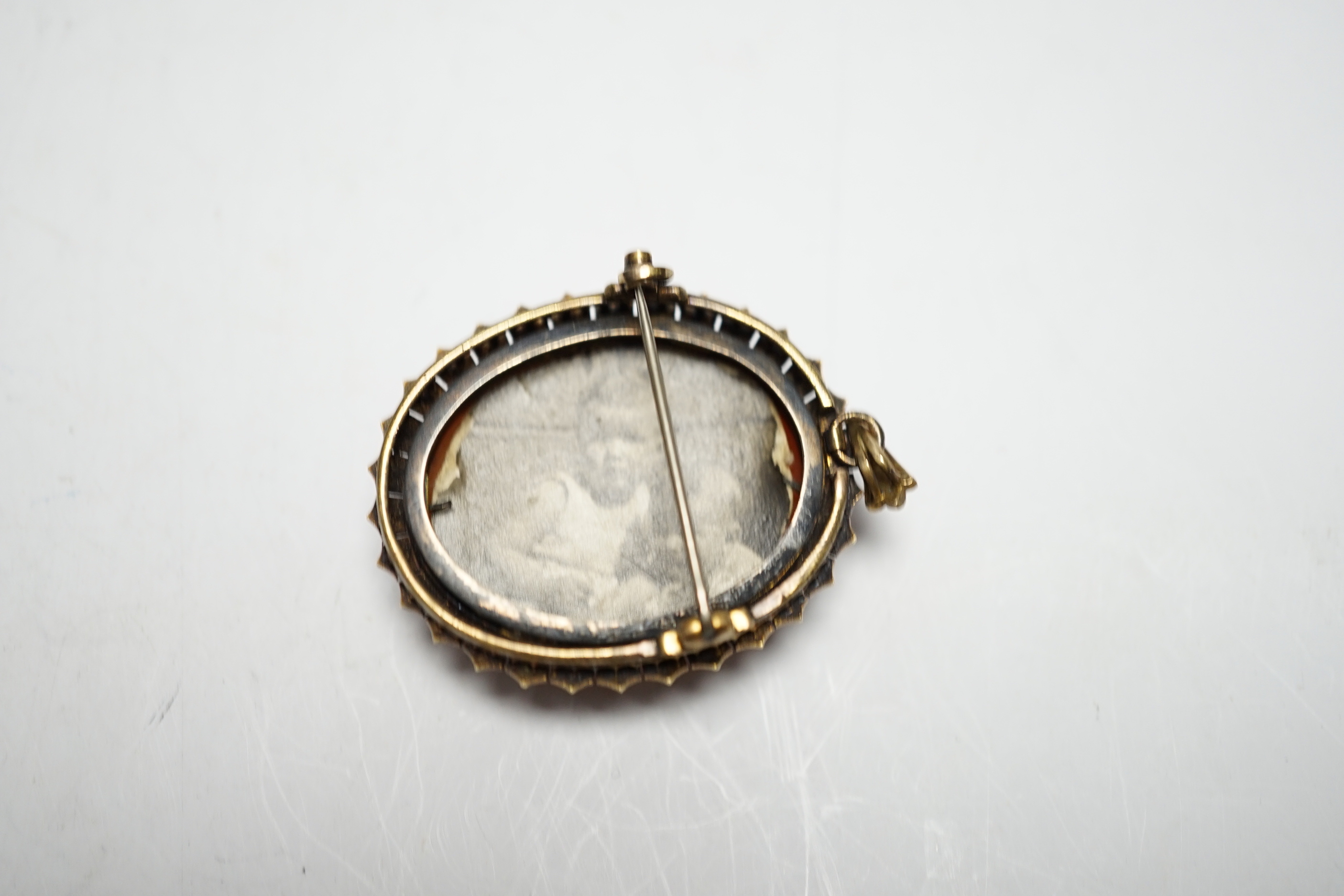 A Victorian yellow metal, and seed pearl mounted oval hardstone cameo pendant brooch, carved with the bust of a lady to dexter, 39mm.